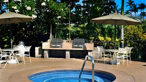 Un espace extérieur avec piscine, barbecue intégré et coin salon.
