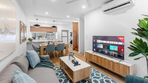 A modern living room with a sofa, coffee table, and a flat-screen TV.