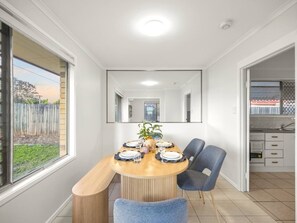 A dining area with a round table, chairs, and a view of the outside. - Heart of Sunnybank | Prime Location | Great Value (Sunnybank)