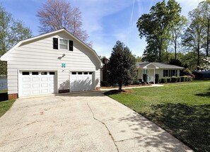 A single-story house with a garage, a covered porch, and a well-maintained lawn. - Simple Lake house in charming Summerfield with exceptional lake views! (Summerfield)