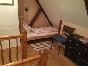 Ein Schlafzimmer mit Schlafbox, einem kleinen Schreibtisch und einer Kommode.