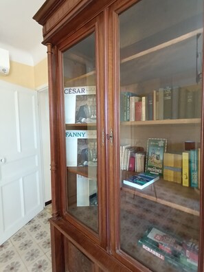A wooden bookcase with glass doors, containing various books and a Scrabble game. - A typical Provençal house, just a 10-minute walk from Almanarre Beach! (Hyères)