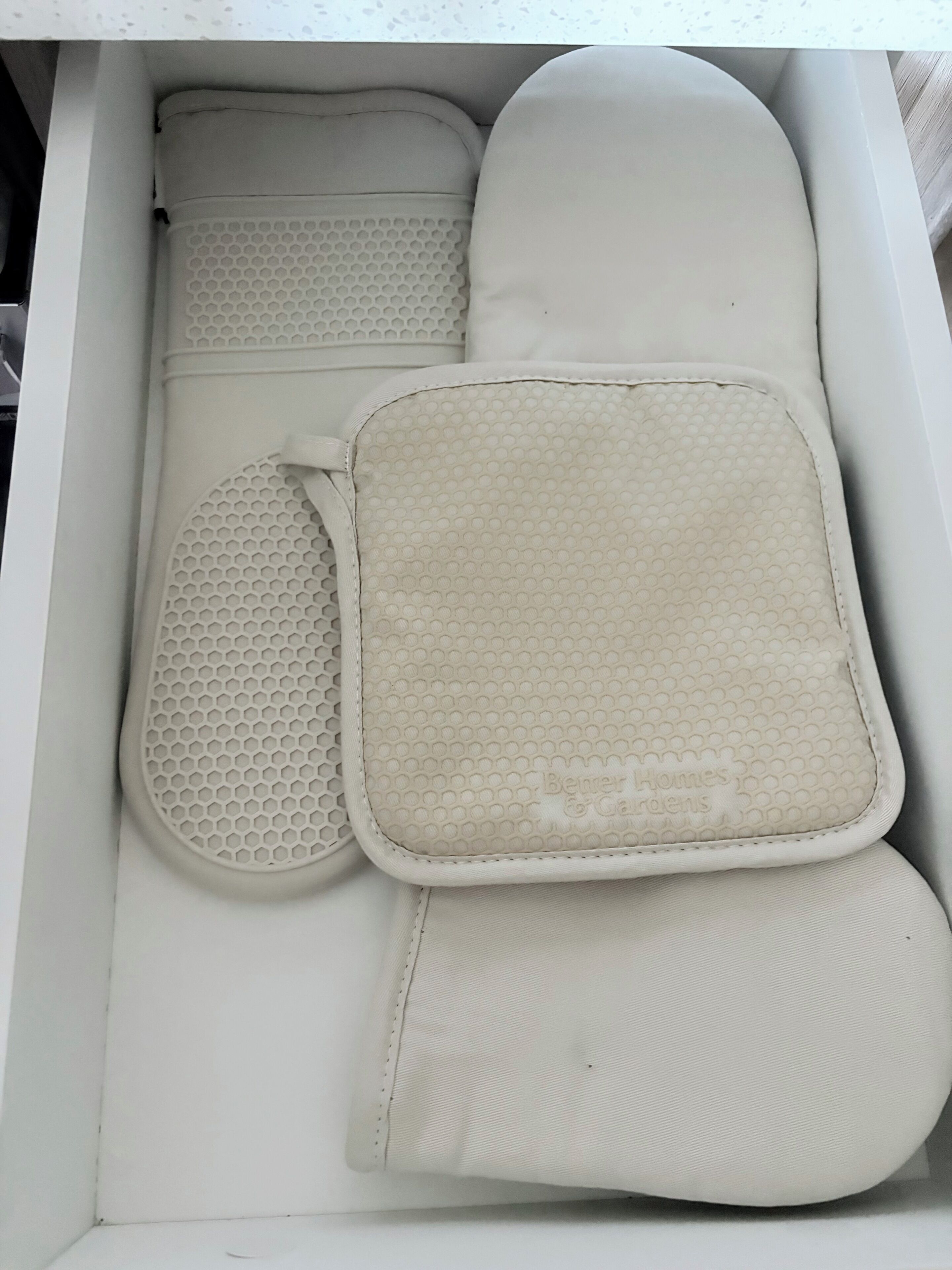 Eine weiße Aufbewahrungsbox mit einer zusammengeklappten Matratze, einem Kopfkissen und einer Decke.