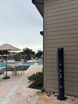 Ein Poolbereich mit Terrasse, Stühlen und Tisch.