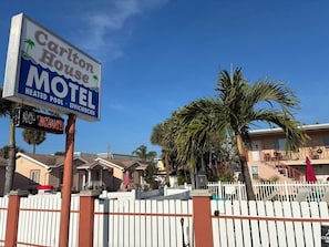 Een motel genaamd Carlton House, met een bord waarop staat dat er een verwarmd zwembad en efficiënte voorzieningen zijn.