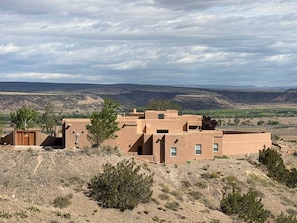 Wüstenlandschaft mit einem mehrstöckigen Gebäude im Pueblo-Stil, das mehrere Zimmer und ein flaches Dach besitzt.