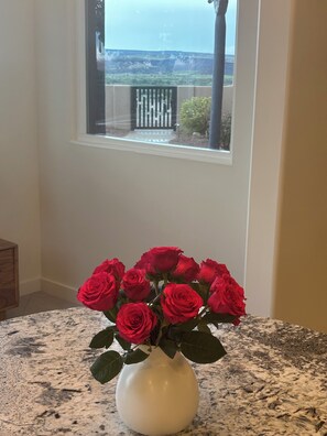 Eine weiße Vase mit roten Rosen auf einer Granit-Arbeitsplatte.