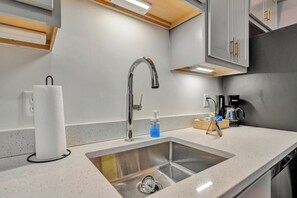 A modern kitchen with a stainless steel sink, a faucet, and a coffee maker. - Executive Studio - Nearby Parking - Downtown - 3F (Louisville)