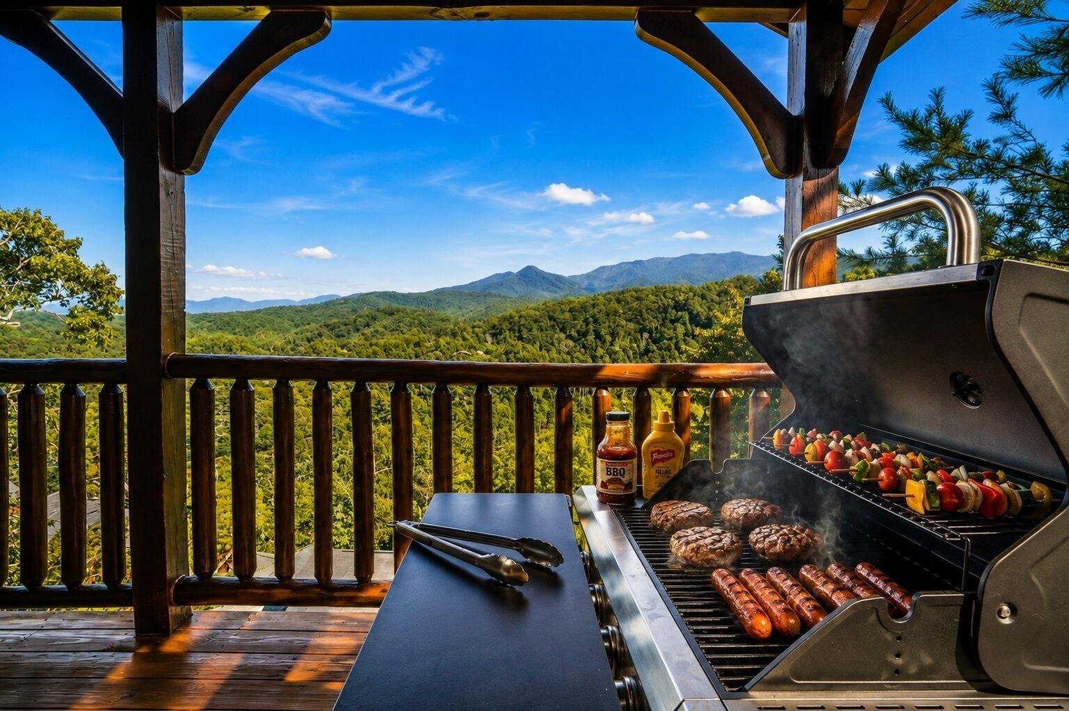 An outdoor grill with skewers and sausages, a bottle of barbecue sauce, and a pair of tongs on a wooden deck with a view of mountains and trees.