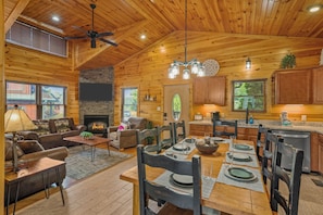 A spacious log cabin interior with a dining area, fireplace, and kitchen. - Sleeps 8, Mountain View Hot Tub, Arcade, Pool Table, 2 Mi to Gatlinburg Parkway (Gatlinburg)