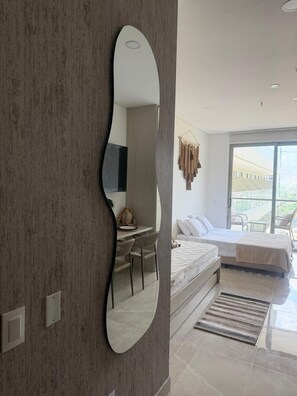 A modern bedroom with a large bed, a desk, and a chair. - Oceanfront Apartment in Bello Horizonte 1416 (Santa Marta)