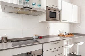 A modern kitchen with a built-in oven, microwave, and stainless steel range hood. - Live the nomad life, fast Wi-Fi, Gaudí, sunshine, and tapas (Barcelona)