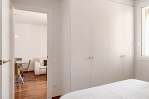 Une chambre à coucher comprenant un lit, une armoire et un bureau avec des chaises.