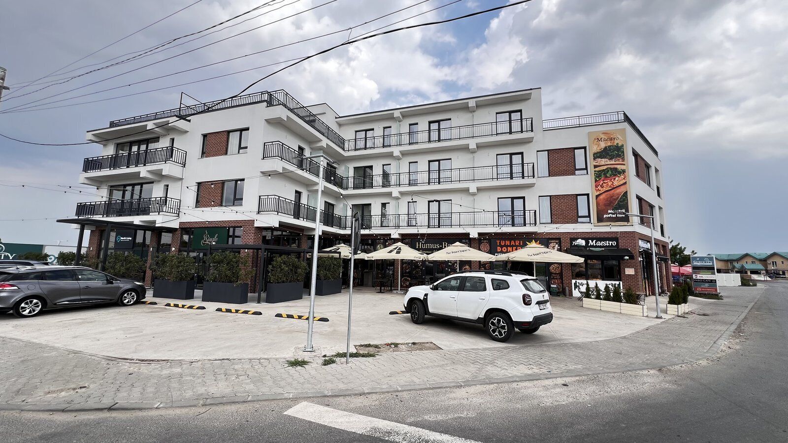 Un immeuble à plusieurs étages qui abrite un restaurant appelé « Maestro » au rez-de-chaussée.