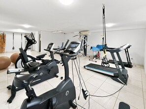 Ein Heimfitnessraum mit Ergometer, Laufband und Übungsbällen.