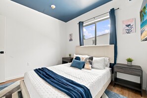 A bedroom with a bed, bedside tables, a window with curtains, a ceiling light, and wall art. - Lovely Wynwood getaway! Large rooms (Miami)
