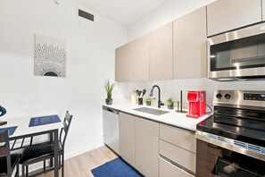 A modern kitchen with a dishwasher, sink, stove, and microwave. - Lovely Wynwood getaway! Large rooms (Miami)