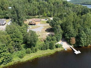 A lakeside property with a dock, a house, and a boat.