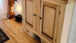 A wooden staircase with a TV mounted above a cabinet.