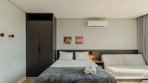 A modern hotel room with a bed, bedside table, and a sofa. - Studio in Cond. w/ Pool Near Redencao Park Tco0802 (Porto Alegre)