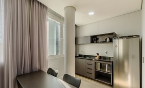 A compact kitchen with a built-in microwave, a coffee maker, and a refrigerator. - Studio in Cond. w/ Pool Near Redencao Park Tco0802 (Porto Alegre)