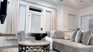 Una sala de estar moderna con un sofá curvo, una mesa de centro redonda y un ventilador de techo.