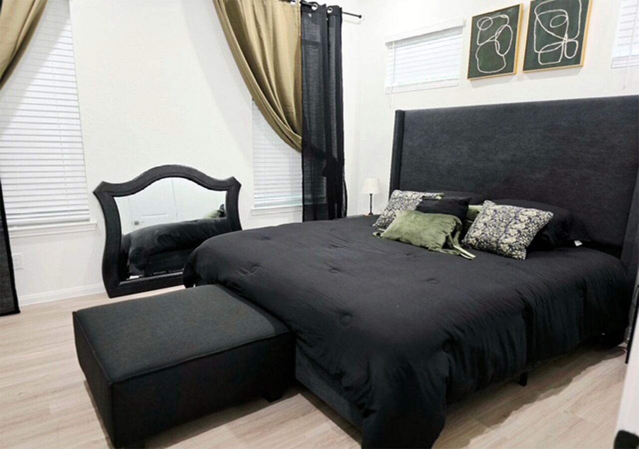 Une chambre à coucher avec un grand lit, une table de chevet et une chaise.