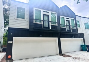 A two-story house with a garage, a balcony, and a mailbox. - Quaint Duplex near everything medical center , downtown , pearland (Houston)