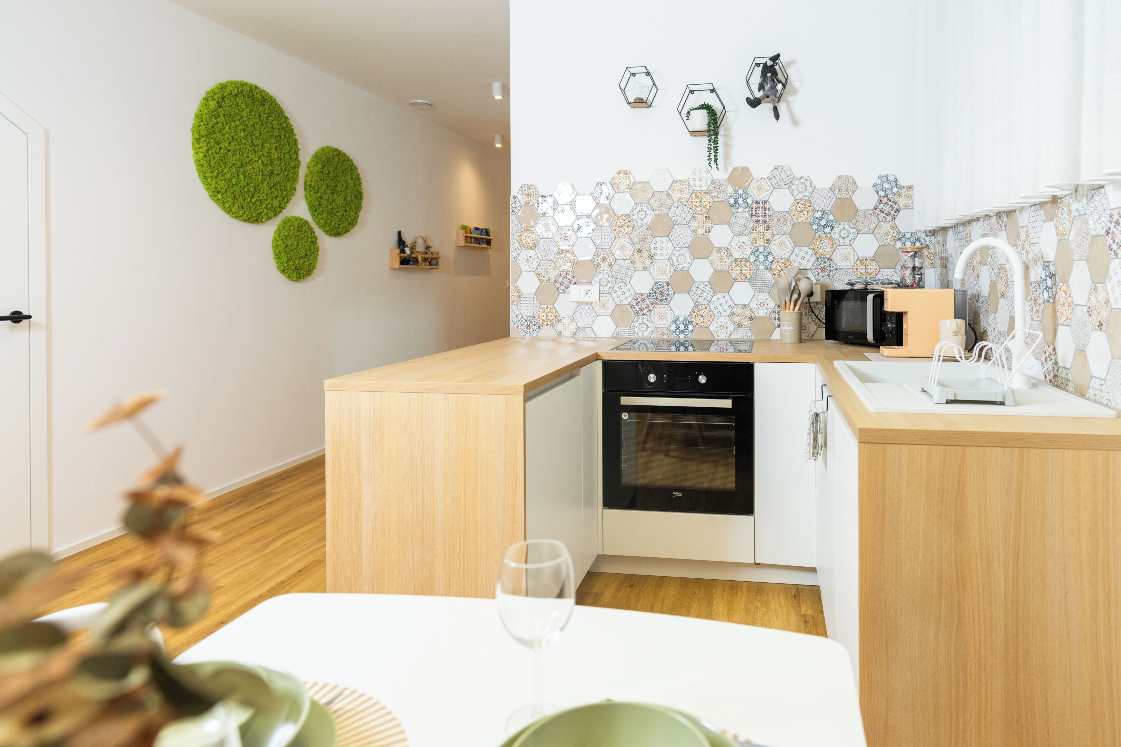 Une cuisine moderne avec des meubles en bois, un four encastré et un four à micro-ondes.