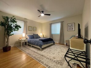 A bedroom with a bed, bedside tables, a ceiling fan, a potted plant, and a television. - Spacious 1-Bedroom Duplex Vance Villa in UPTOWN Lexington (Lexington)