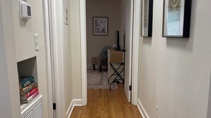 A hallway with wooden flooring, white walls, and a door leading to another room. - Spacious 1-Bedroom Duplex Vance Villa in UPTOWN Lexington (Lexington)