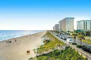 A beachside hotel with a long promenade, beachfront access, and a parking area. - Ocean View Resort Condo, Private Balcony, & Shared Hot Tub, Pool, Tennis (Miramar Beach)