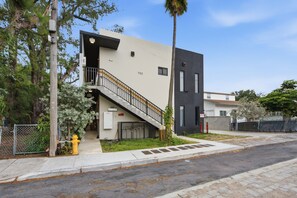 A modern two-story building with a visible fire hydrant, a staircase, and a gated entrance. - Cozy Fun and Vibrant Central Wynwood! King Bed! (Miami)