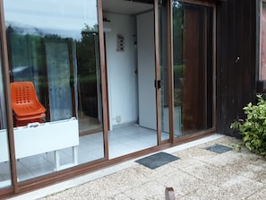A room with a sliding glass door, a white bench, and a small potted plant. - Ideal Vacation (Onnion)