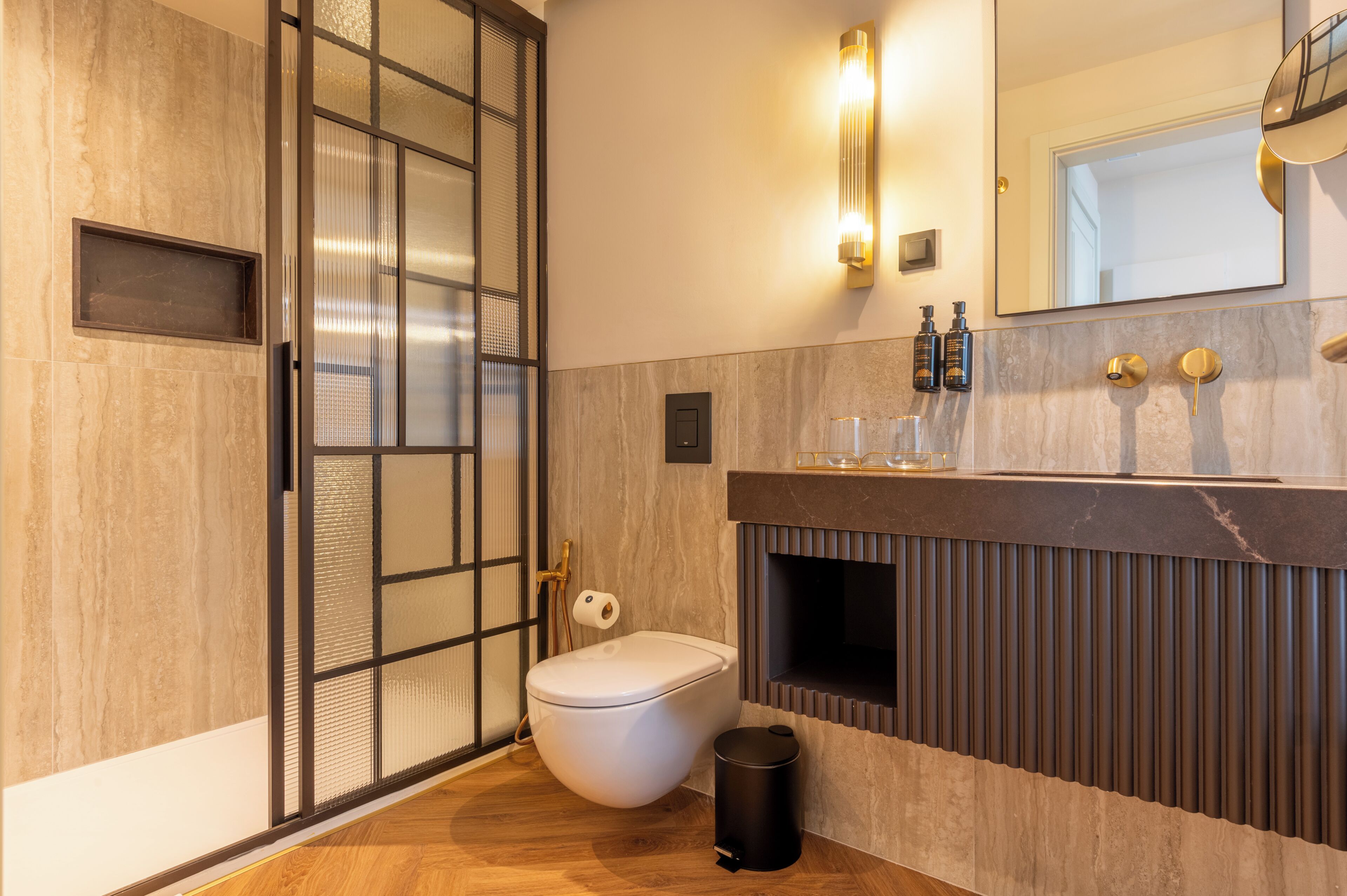 Un baño moderno con inodoro, bidé y tocador con espejo.