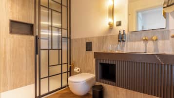 A modern bathroom with a toilet, bidet, and a vanity with a mirror.