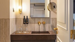 A modern bathroom with a vanity, mirror, and towel rack. - Augusta Grand Hotel (Lisbon)