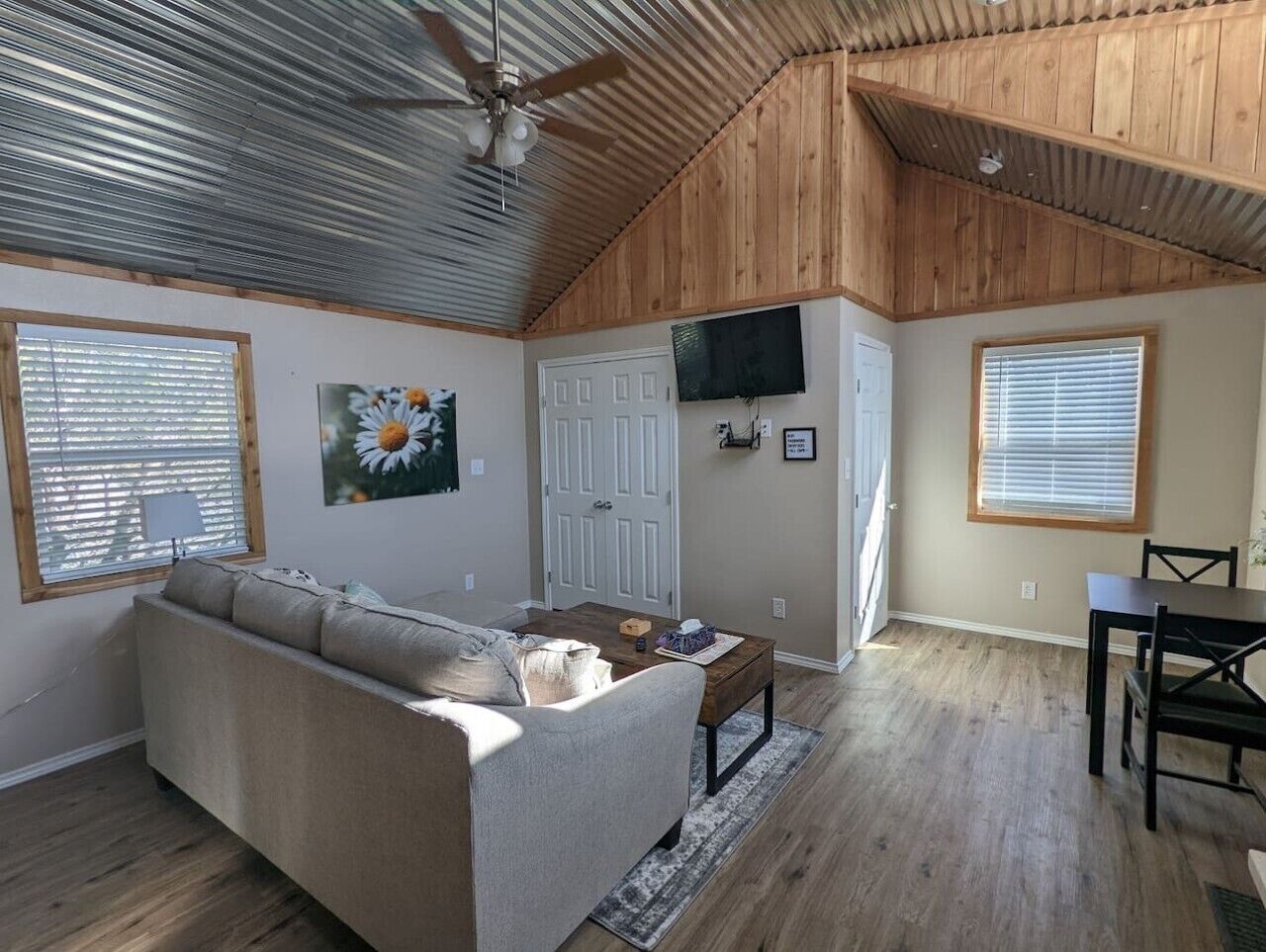 A living room with a sofa, a coffee table, and a dining area with a table and chairs.