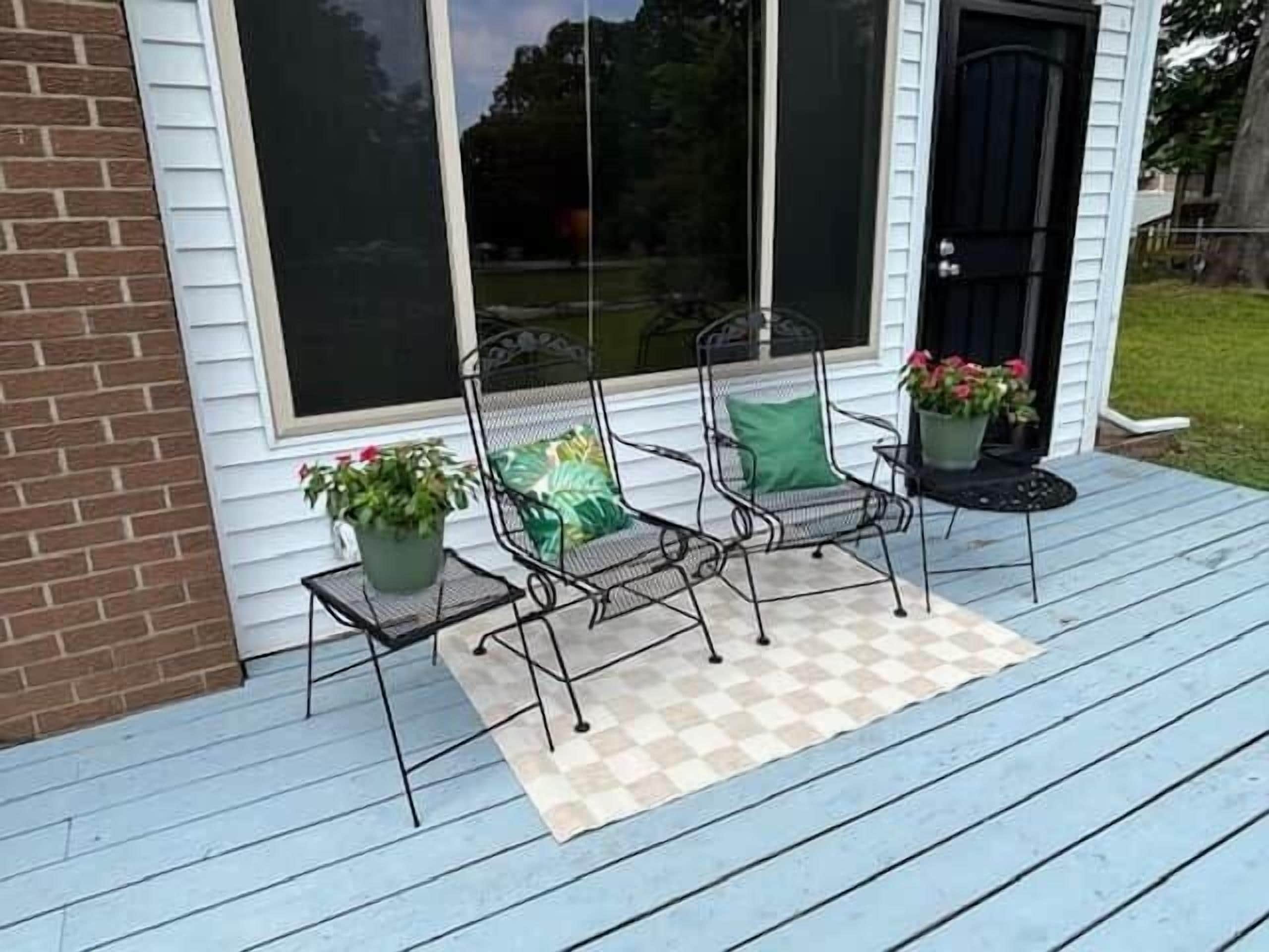 Een veranda met twee stoelen en potplanten.