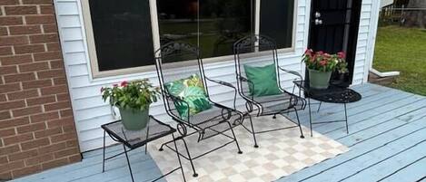 Een veranda met twee stoelen en potplanten.
