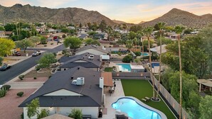 A residential area with houses, a swimming pool, and mountains in the background. - Desert Retreat with Pool & Mountain Views (Phoenix)