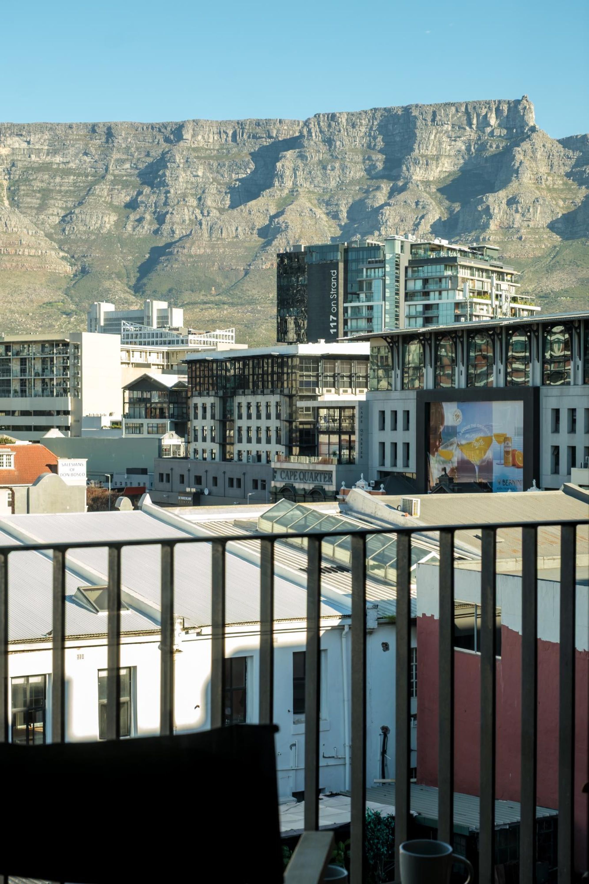 A modern building with a glass facade and a mountain backdrop.