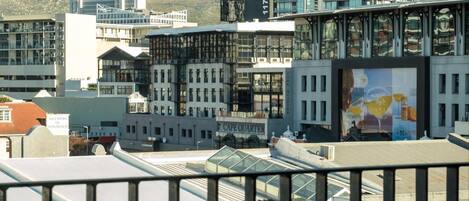 A modern building with a glass facade and a mountain backdrop.