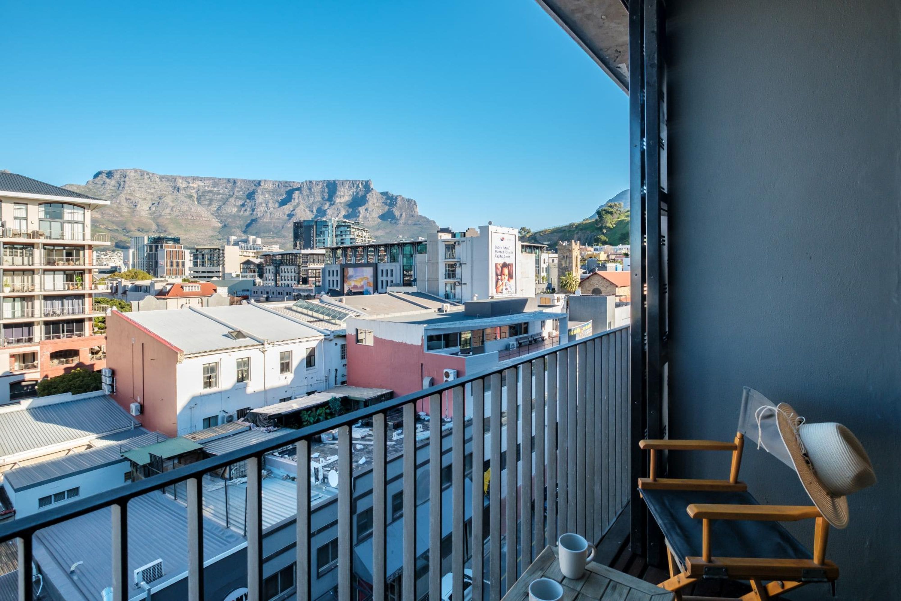 Ein Balkon mit Blick auf eine Stadtlandschaft und Berge.