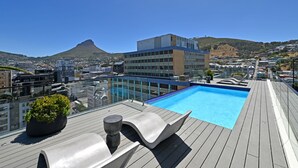A rooftop pool with a clear view of a cityscape and a mountain in the background. - Stylish | Roof Top Pool | Studio Apartment | The Tokyo (Cape Town)