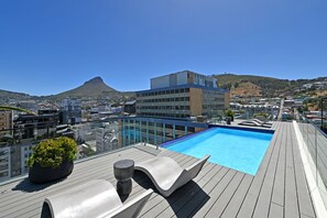 A rooftop pool with a clear view of a cityscape and a mountain in the background. - Stylish | Roof Top Pool | Studio Apartment | The Tokyo (Cape Town)