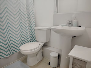Ein Badezimmer mit Toilette, Waschbecken und Mülleimer.