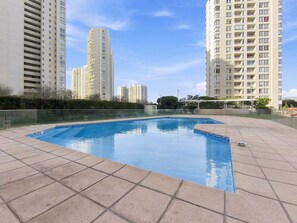 A swimming pool surrounded by high-rise residential buildings. - Oceana Suites La Serena Peñuelas (Coquimbo)