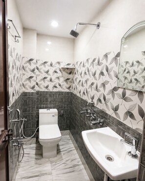 Ein Badezimmer mit Toilette, Bidet, Waschbecken und Dusche.