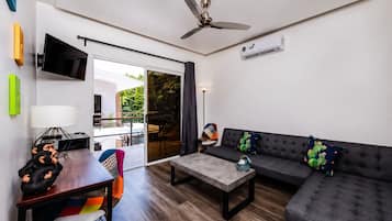 A modern living room with a sofa, coffee table, and a dining area with chairs.